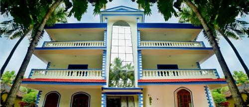 a building with palm trees in front of it at Valeria's Holiday Home in Cavelossim