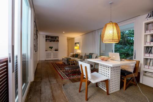 a living room with a table with a laptop on it at Tropical Contemporary Suites in Paraty