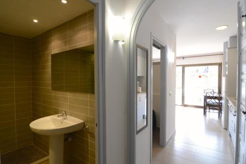 uma casa de banho com um lavatório e um espelho em Jardins del Mar 48 em L'Estartit