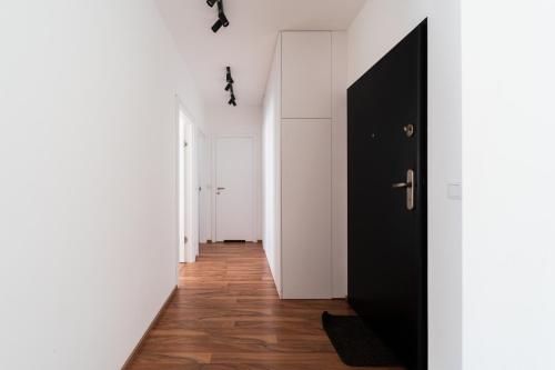 a hallway with a black door and white walls at Big Apart - Atal Towers - 3 Rooms - Private Parking Place in Wrocław