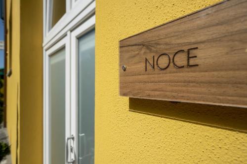 un panneau en bois sur le côté du bâtiment dans l'établissement Casadelfalegname NOCE, 