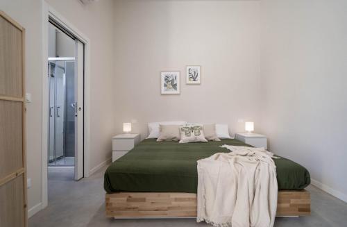 - une chambre avec un lit doté d'une couverture verte dans l'établissement Casadelfalegname NOCE, 
