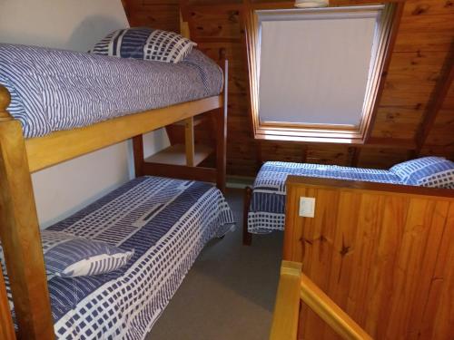 a bedroom with two bunk beds and a window at Complejo Paimun in San Martín de los Andes