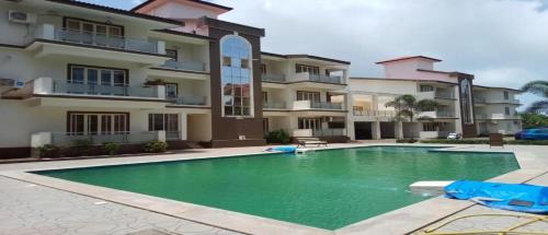 a swimming pool in front of a apartment building at 1 BHK Apartment for rent in Varca - We Comforts in Varca