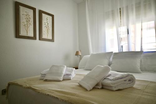 1 dormitorio blanco con toallas en una cama con ventana en For You Rentals Coqueto y Cómodo apartamento Madrid, en Madrid