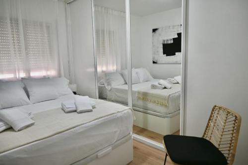 1 dormitorio con espejo, 1 cama y 1 silla en For You Rentals Coqueto y Cómodo apartamento Madrid, en Madrid
