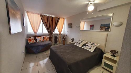 ein kleines Schlafzimmer mit einem Bett und einem Fenster in der Unterkunft Albatros in Los Cristianos
