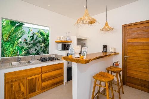a kitchen with a sink and a counter with stools at Villa Zahka - 1BR Private Luxury Hideaway near Seseh Beach in Canggu