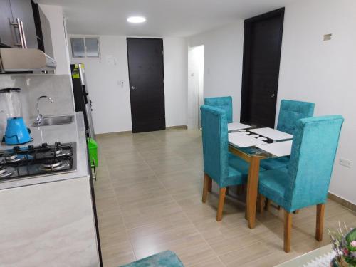 a kitchen with a table and chairs and a stove at El Velero Apartamentos By DANP in Santa Marta