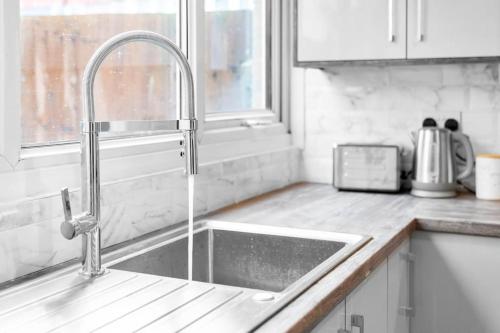 eine Küchenspüle mit einem Wasserhahn in der Küche in der Unterkunft JLR,NEC,B'Ham Airport,Entire House,WI-FI,Netflix in Birmingham