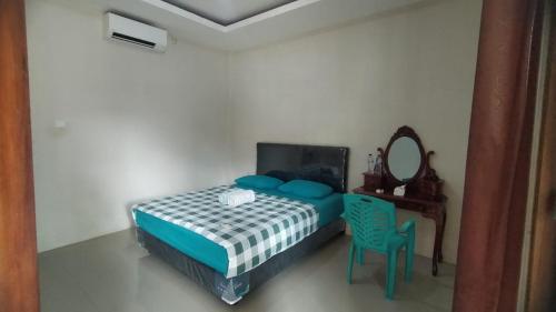 1 dormitorio con cama, mesa y espejo en WL GUESTHOUSE, en Labuan Bajo