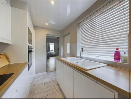 een keuken met een wastafel en een raam bij The Terrace Hoole, cosy modern 2 bedroom house in Chester