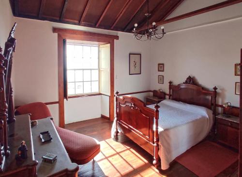um quarto com uma cama de madeira e uma janela em Villa Asunción A em Breña Baja
