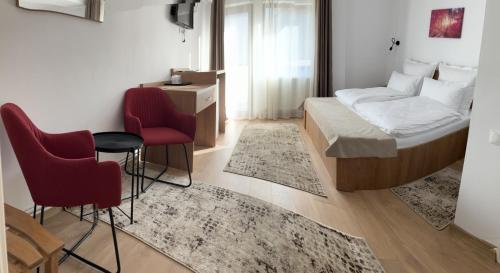 1 Schlafzimmer mit einem Bett, 2 Stühlen und einem Tisch in der Unterkunft Casa BABI in Căciulata