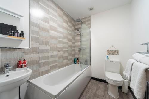 a bathroom with a tub and a toilet and a sink at Hull Ground Floor 1 Bedroom Apt 3 beds Spacious Jesouth Striking in Hull
