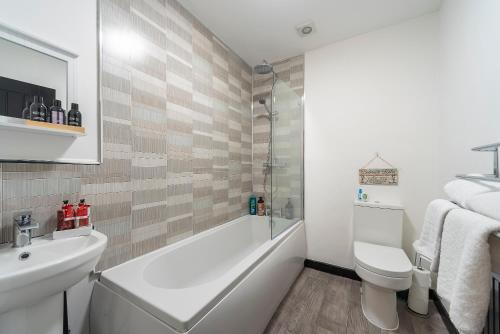 a bathroom with a tub and a toilet and a sink at Hull 1 Bedroom Apt 3 beds Spacious Jesouth Striking in Hull