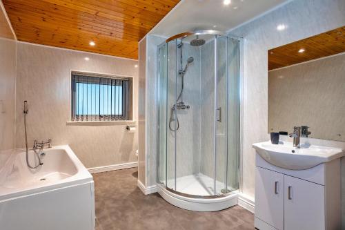 a bathroom with a shower and a sink and a tub at Finest Retreats - Woodstock Lodge in Bishop Middleham