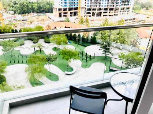 a balcony with two chairs and a view of a park at Genting Premium Suite Windmill Upon Hills by JAz Home Suites in Genting Highlands