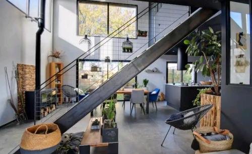 un loft avec un escalier et une salle à manger avec des plantes dans l'établissement Chambre spacieuse dans maison design, à Saint-Herblain