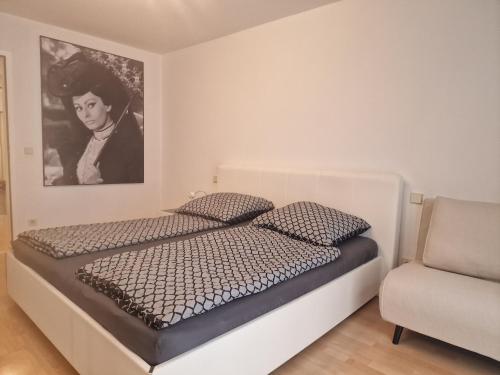a bedroom with a bed with a picture on the wall at Domino Apartment in Baden-Baden