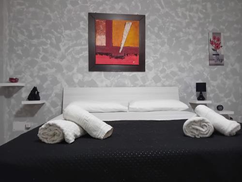 1 dormitorio con 1 cama con sábanas y almohadas blancas en Cusano Home en Maddaloni