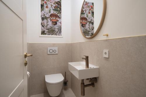 a bathroom with a toilet and a sink and a mirror at SCHLOSSRESIDENZ - Boutique Apartments & Hotel Suiten in Schloß Ricklingen