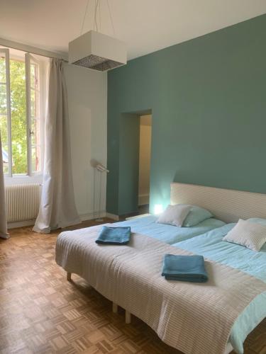 - une chambre avec un grand lit et 2 serviettes bleues dans l'établissement La Dépendance de Bazin, à Marmande