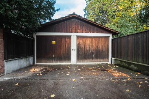 a garage with two doors and a fence at Beautiful Villa in the Heart of Basel in Basel