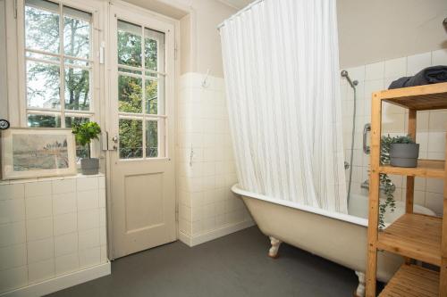 a bathroom with a bath tub and a window at Beautiful Villa in the Heart of Basel in Basel