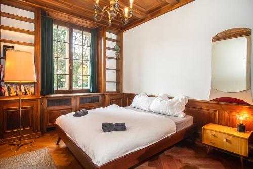 a bedroom with a bed and a lamp and windows at Beautiful Villa in the Heart of Basel in Basel
