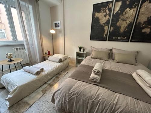 a bedroom with two beds and a table in it at [La Maison du Monde] in Rome