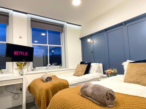 a hotel room with two beds and a television at Central penthouse by HNFC Stays in Newcastle upon Tyne