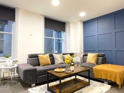 a living room with a couch and a table at Central penthouse by HNFC Stays in Newcastle upon Tyne