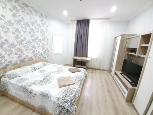 a small bedroom with a bed and a tv at Ultracentral Apartments with 2 Rooms at Stefan cel Mare in Chişinău