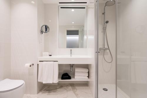 a white bathroom with a sink and a shower at Hotel Morfeo in Milan