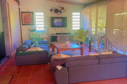 a living room with a couch and a table at Maison de campagne in Kourou