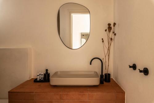 a bathroom with a white tub and a mirror at Nysis Koufonisia in Koufonisia
