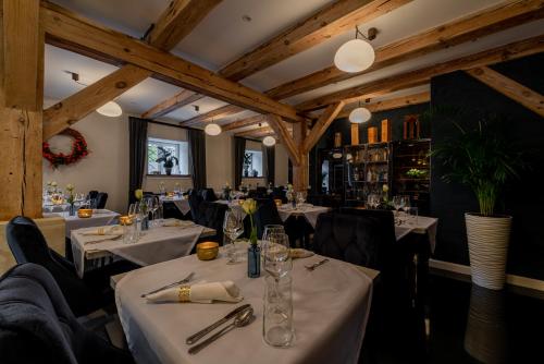 a restaurant with white tables and black chairs at KaJo Apartamenty in Świdwin