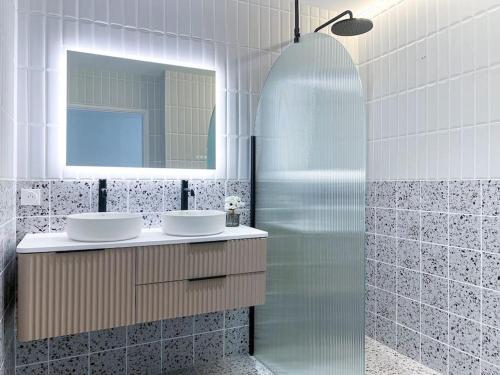 La salle de bains est pourvue de 2 lavabos et d'un miroir. dans l'établissement Villa d'architecte entre lac et montagnes, à Saint-Alban