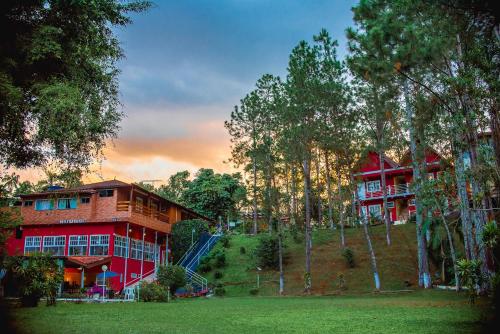 a large red building with trees in front of it at Recanto de Moriá in Penedo