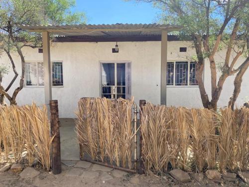a fence in front of a house with trees at Kappsfarm Guesthouse in Voigtland