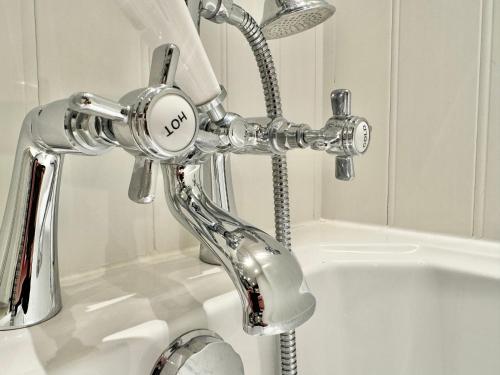 eine Badewanne mit Chrom im Bad in der Unterkunft Chestnut Cottage in Dalmellington