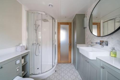 a bathroom with a shower and a sink and a mirror at Luxurious houseboat near Canary Wharf in London in London
