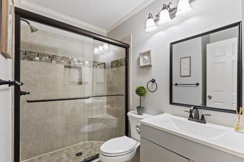 uma casa de banho com um chuveiro, um WC e um lavatório. em Seaside Villa 251 em Hilton Head Island