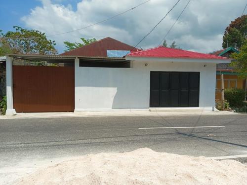 Mandati的住宿－Maria Guesthouse，白色和棕色的房子,有红色屋顶