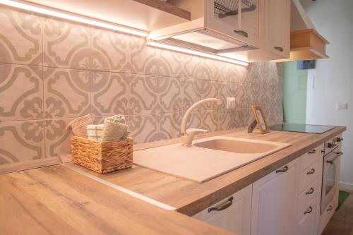 cocina con fregadero y pared estampada en La Casetta. Feel at home., en Castelfidardo