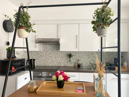 a kitchen with white cabinets and flowers on a table at Appartement Ostend in Ostend