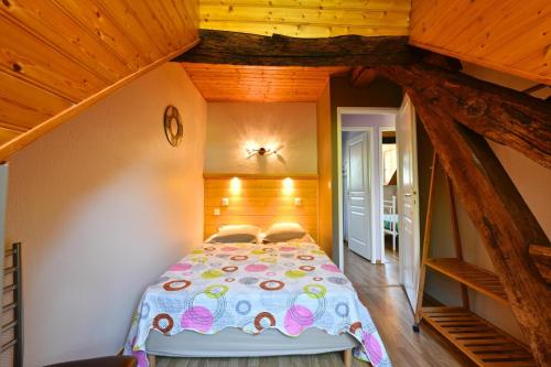 um quarto com uma cama num quarto com tectos em madeira em Le mouly/grand gite em Miossens-Lanusse
