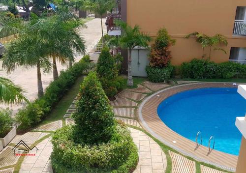 a swimming pool in front of a building with palm trees at Palawan Luxury 2BR Condo with Pool, Gym & Parking - B1 5Kunzite in Puerto Princesa City
