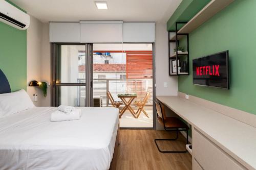 a bedroom with a bed and a desk with a view at Axis Vila Mariana - Studios por temporada in Sao Paulo